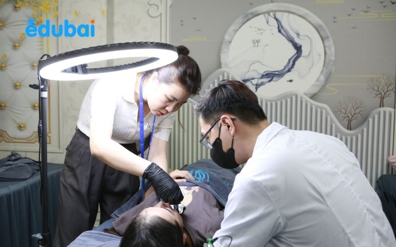 Kỹ thuật viên đang thực hành phun xăm thẩm mỹ trên người mẫu thật